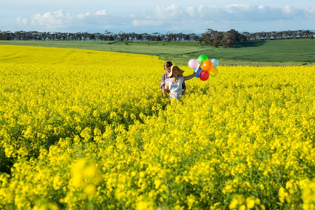 Para trzyma kolorowych balony w musztardy polu
