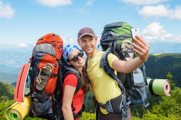 Para turystów robiących sobie selfie z widokiem na góry w tle