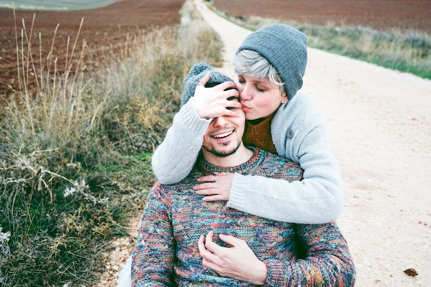 Zdjęcie para uściskająca się podczas siedzenia na drodze w zimie