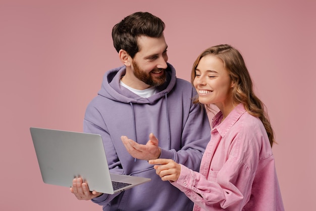 Para uśmiechniętych przyjaciół trzymających laptop wybierający wyodrębnione towary