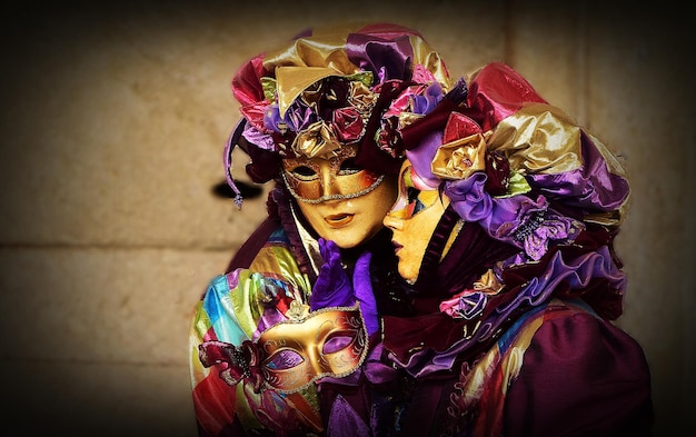 Para w pasujących kostiumach, głównie w fioletowych i jasnych kolorach na karnawale w Wenecji