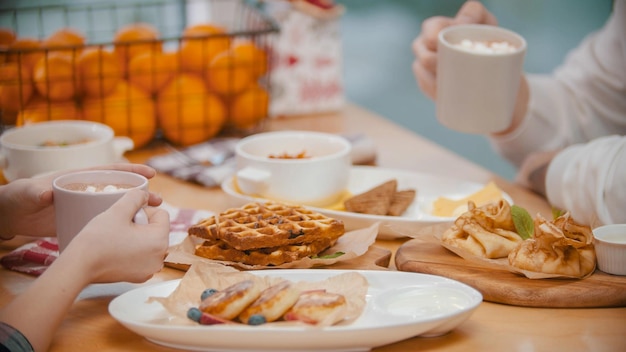 Para w restauracji jedząca śniadanie składające się z gofrów i naleśników