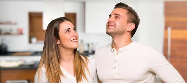 Para w walentynki przyglądający up podczas gdy ono uśmiecha się w domu
