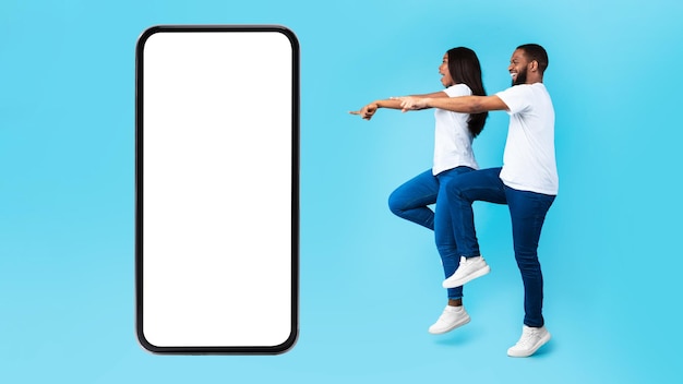 Para wskazująca na dużą białą pustą makieta ekranu smartfona