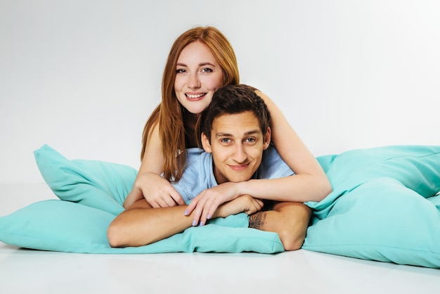 Para zakochanych facet i dziewczyna uśmiecha się i wygłupia leżąc na poduszkach