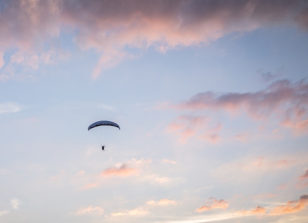 Paraglider lata nad górami w letnim dniu