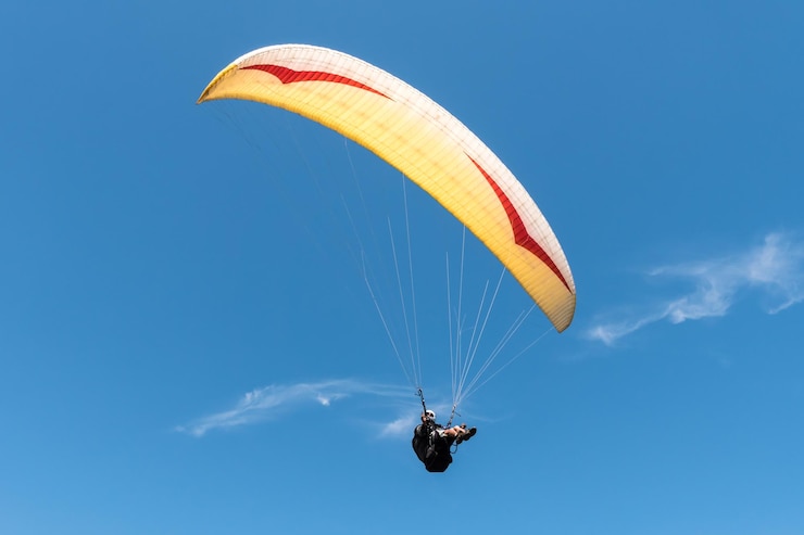 Zdjęcie paraglider latający na niebieskim niebie