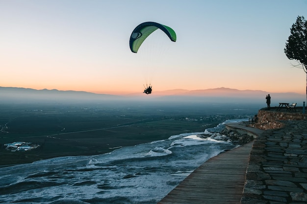 Paraglider latający nad wschodem słońca Koncepcja sportu ekstremalnego podejmująca wyzwanie przygody
