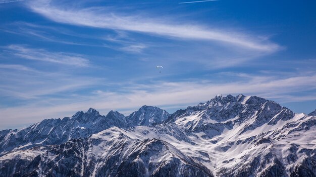 Paralotniarstwo nad Alpami z górskimi klifami pokrytymi śniegiem w Karnten w Austrii