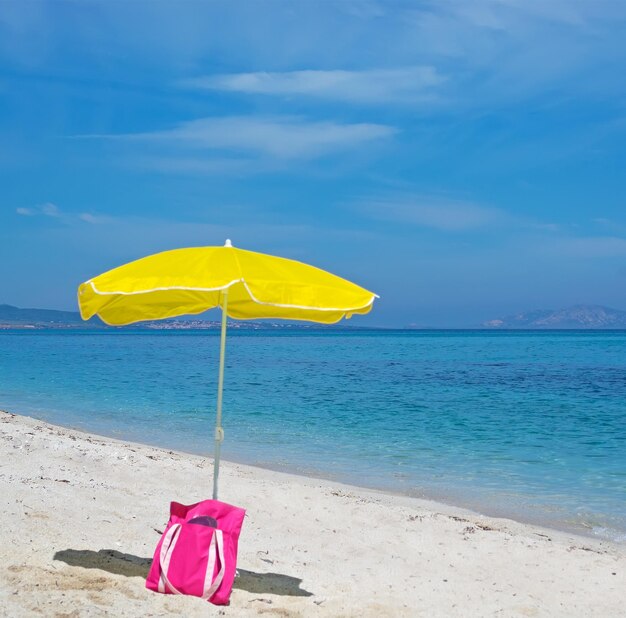 Parasol i torba na bezludnej plaży