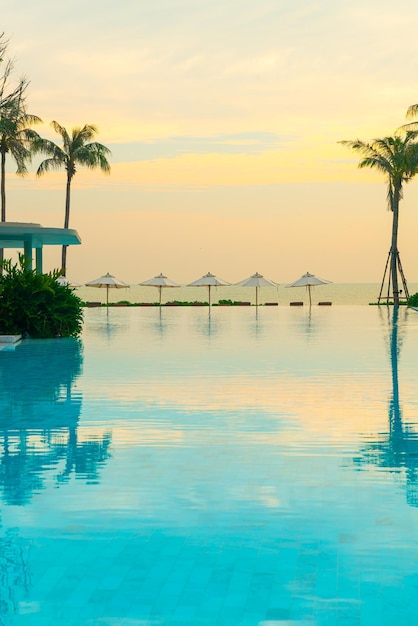 parasol z basenem wokół basenu z tłem oceanicznego morza - koncepcja wakacji i wakacji