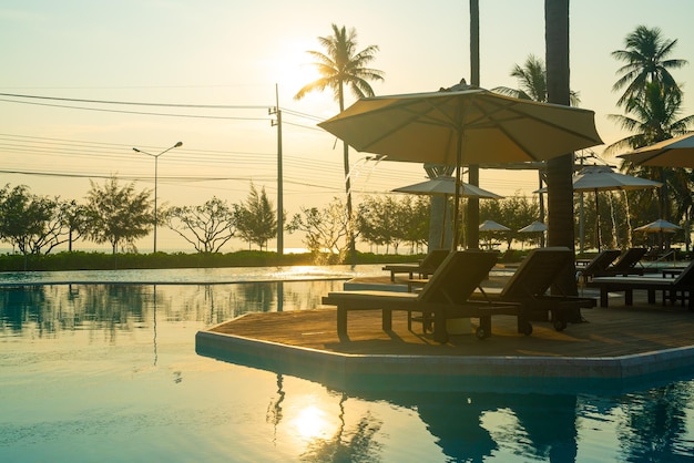 parasol z basenem wokół basenu z tłem oceanicznego morza - koncepcja wakacji i wakacji
