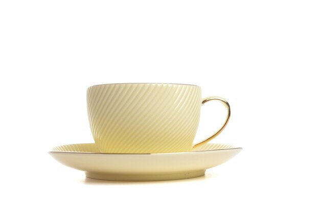 Parę herbat ze spodkiem w kolorze cytrynowym ze złotym wykończeniem wykonanym z porcelany na białym na białym tle