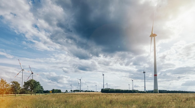 Park turbin wiatrowych w krajobrazie rolnictwa z zachmurzonym niebem. idealny do układów stron internetowych i czasopism