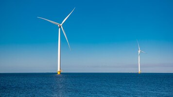 Zdjęcie park wiatraków w oceanie drone widok z lotu ptaka turbin wiatrowych generujących zieloną energię wiatraków elektrycznych na białym tle na morzu w holandii