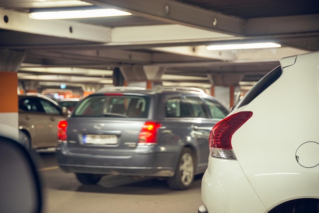 Parking podziemny Różne samochody stojące na parkingu podziemnym w centrum handlowym