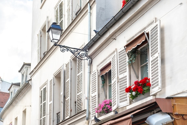 Paryskie okna z kwiatami na ulicy Montmartre