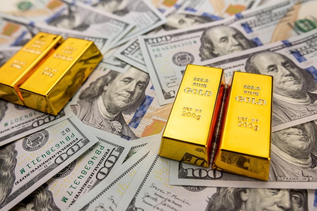 Pasek złota przeznaczone do walki radioelektronicznej leżącego na 100 banknotów Dolar Złoto bulionowe i koncepcji pieniędzy