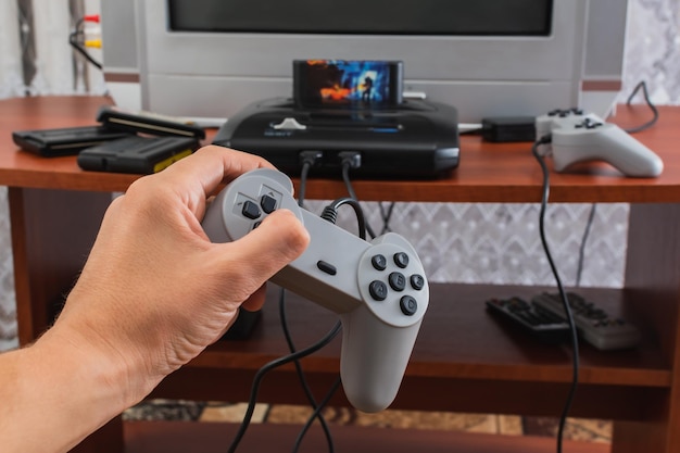 Pasja do gier komputerowych i konsolowych Proces grania w gry w środowisku domowym Ręka trzymająca kontroler gry