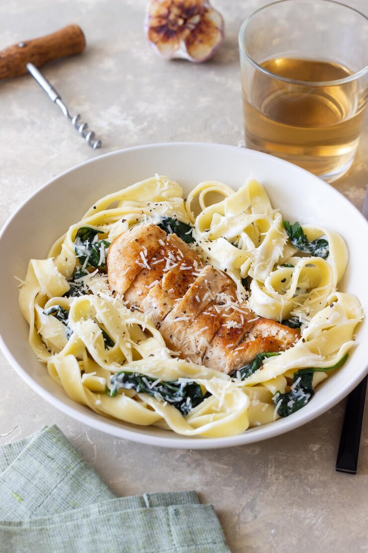 Pasta alfredo z kurczakiem, szpinakiem i serem, włoskie jedzenie