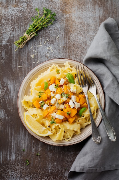 Pasta Mafaldine Napoletane Z Pieczoną Dynią, Serem Feta I Przyprawami Na Talerzu Ceramicznym. Styl Rustykalny. Widok Z Góry.