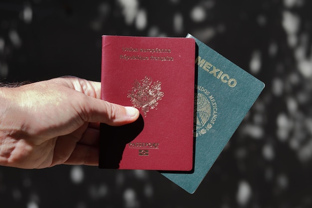 Paszport francuski i meksykański trzymany w ręku