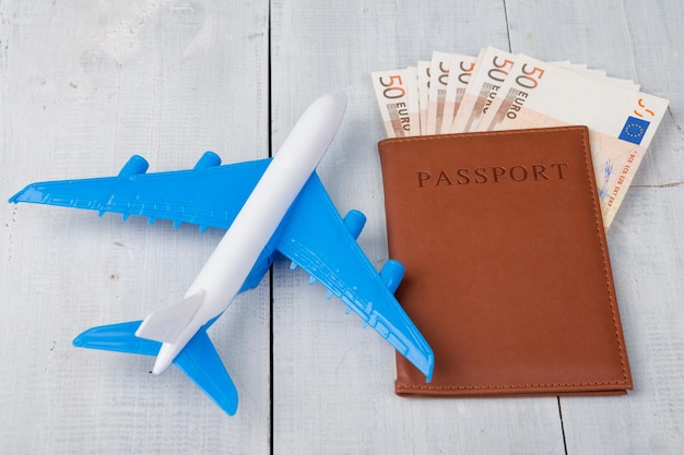 Paszport lotniczy i papierowe pieniądze na białym drewnianym stole