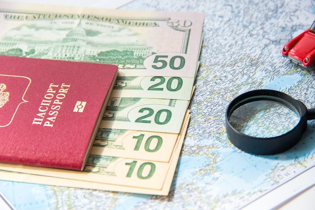 Paszport lupa czerwony samochodzik i pieniądze na mapie Koncepcja planowania budżetu