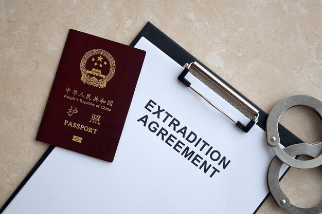 Paszport Republiki Chińskiej i umowa o ekstradycji z kajdankami na stole