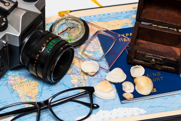 Zdjęcie paszporty na mapie świata. aparat, okulary przeciwsłoneczne i muszle w tle