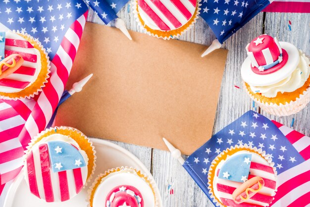 Patriotyczne babeczki USA nad flagami na stół z drewna