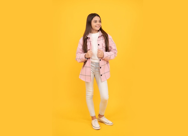 Patrząc fajnie najnowszy trend jesień moda szczęśliwa nastolatka w różowej kraciastej koszuli uśmiechnięta hipster dzieciak styl casual tween odzież dziecięca koszula w kratę flanelowa kurtka w kratę uroda i moda