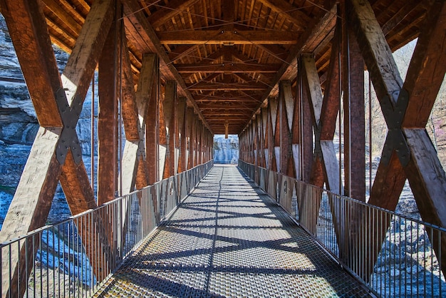 Patrząc w dół długiego mostu spacerowego z drewna i metalu