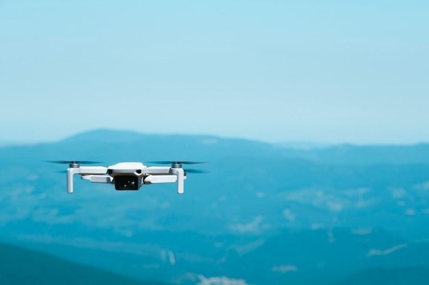 Patrzenie w dół na zdalnie sterowany dron quadkoptera podczas lotu w słoneczny dzień