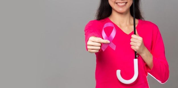 Październikowy miesiąc świadomości raka piersi dorosła kobieta w różowej sukience, trzymająca różową wstążkę i parasol dla wspierania ochrony, międzynarodowe miejsce na kopię koncepcji dnia matki i świata na raka