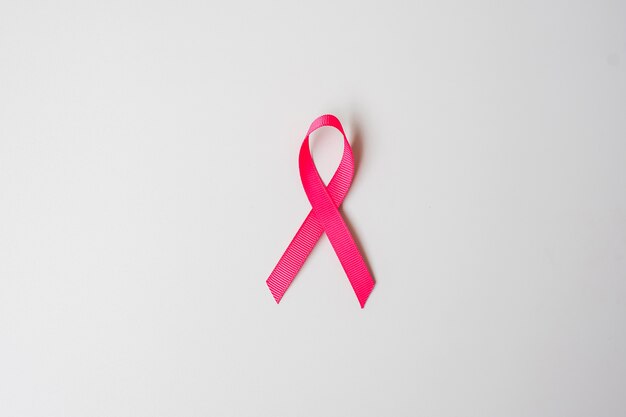 Październikowy miesiąc świadomości raka piersi, różowa wstążka na szarym tle do wspierania osób żyjących i chorych. Koncepcja międzynarodowego dnia kobiet, matki i światowego dnia raka