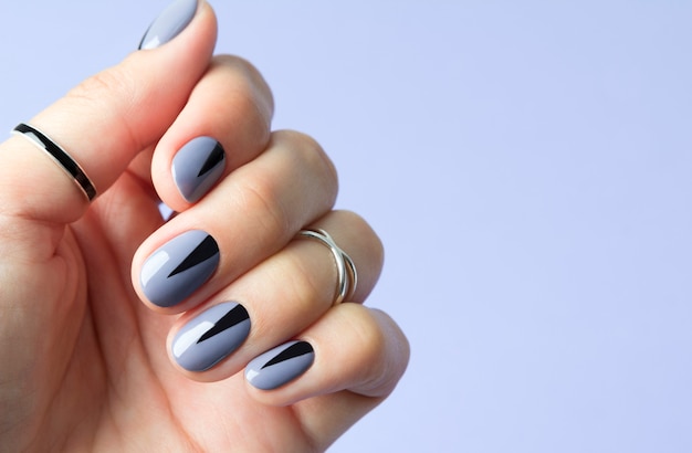 Paznokcie pięknej kobiety z geometrycznym minimalistycznym manicure