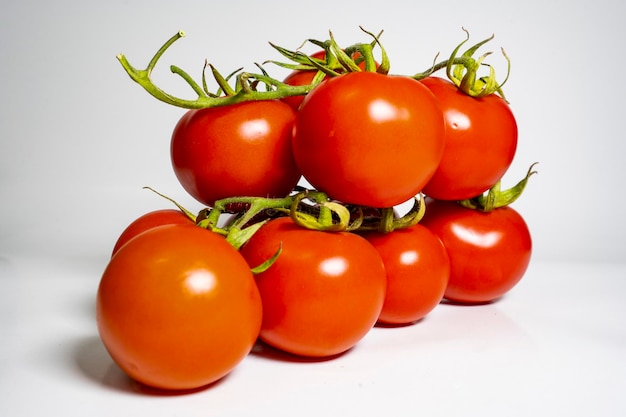 pęczek czerwonych świeżych pomidorów na białym tle