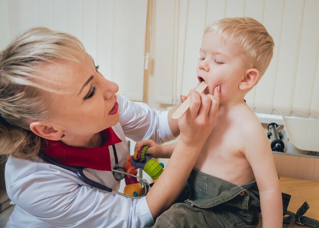 Pediatra Bada Noworodka Za Pomocą Szpatułki