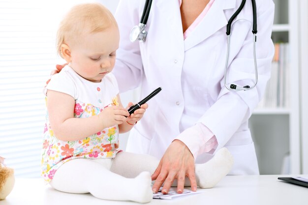 Pediatra opiekuje się dzieckiem w szpitalu Mała dziewczynka jest badana przez lekarza za pomocą stetoskopu Ubezpieczenie zdrowotne i koncepcja pomocy