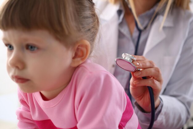 Pediatra słucha stetoskopem płuc dziewczynki