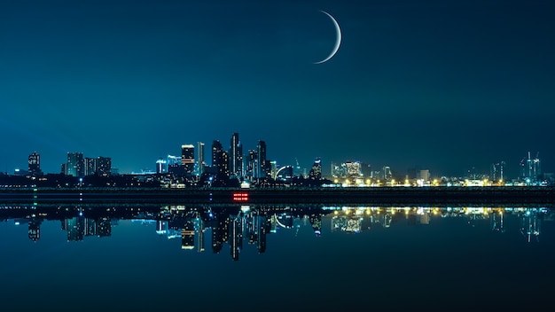 Pejzaż miasta nocą z księżycem i panoramą miasta w tle