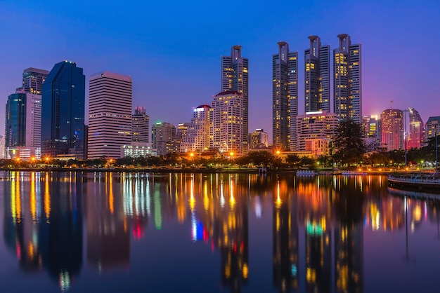 Zdjęcie pejzaż miejski przy nocą przy parkiem z handlowym budynkiem, bangkok, tajlandia.