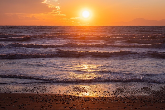 Pejzażowa natura pięknego zachodu słońca na niebie na plaży i kolorowy błyszczący ocean morski w słoneczny dzień