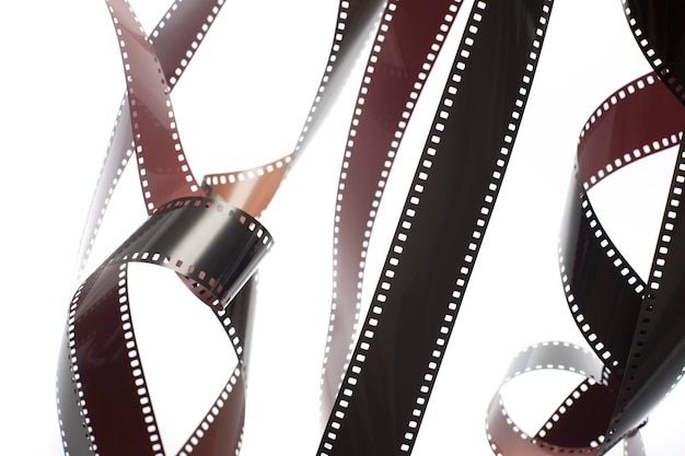 Pęknięcie rozwiniętych odsłoniętych pasków filmowych 35 mm na białym tle w koncepcji fotografii retro