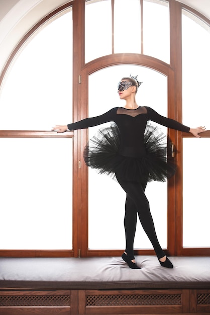 Pełen wdzięku balerina w czarnej sukni łabędzia na tle wgite Młoda tancerka baletowa ćwicząca przed występem w czarnej tutu przestrzeni kopii studio tańca klasycznego