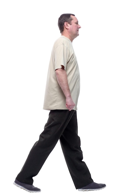 Pełen wzrostu mężczyzna w lekkiej koszulce kroczy naprzód