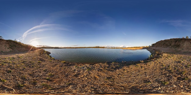 Zdjęcie pełna bezszwowa panorama 360 kątów w pobliżu kamieniołomu zalanego wodą do wydobywania piasku w wieczornym słońcu w równoprostokątnej sferycznej projekcji w równej odległości dla treści vr ar