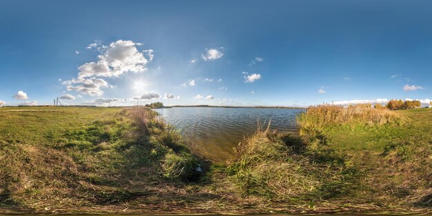 Pełna bezszwowa panorama sferyczna 360 stopni kąt widzenia złota jesień w pobliżu brzegu szerokiego jeziora w słoneczny dzień Panorama 360 w projekcji równoprostokątnej gotowa zawartość wirtualnej rzeczywistości VR AR