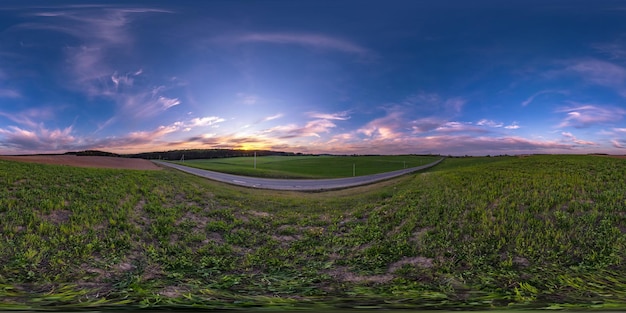 Zdjęcie pełna bezszwowa sferyczna panorama hdr 360 stopni kąt widzenia wśród pól w letni wieczór zachód słońca z niesamowitymi niebieskimi różowymi czerwonymi chmurami w projekcji równoprostokątnej gotowy do wirtualnej rzeczywistości vr ar